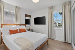 a bedroom with a large bed with a tv on the wall at LA Gramercy in Los Angeles +7 photos