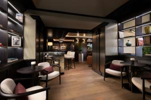 a restaurant with tables and chairs and a bar at Sina De La Ville in Milan