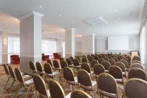 an empty room with rows of chairs and a podium at Sina De La Ville in Milan