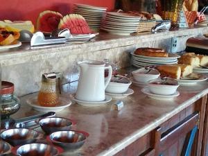 a counter with plates and other dishes on it at Pousada 14 Bis in Petrópolis