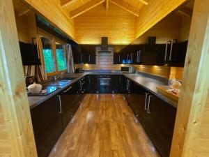 a kitchen with wooden cabinets and a wooden floor at Kingfishers Woody Park in Willand
