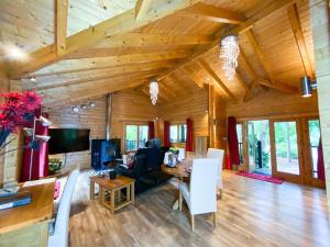 a living room with wooden ceilings and a table and chairs at Kingfishers Woody Park in Willand