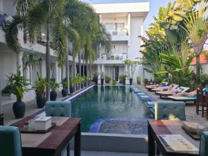 a pool in the middle of a hotel with tables and chairs at Angkor Sweet Night Hotel in Siem Reap