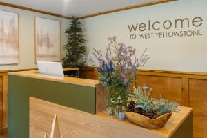 a welcome desk with flowers and a laptop on it at The Evergreen in West Yellowstone