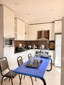 a kitchen with a blue table with wine glasses on it at Suli Hostel in Tbilisi City