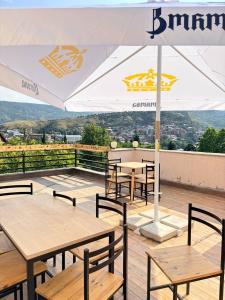 a group of tables and chairs with an umbrella at Suli Hostel in Tbilisi City