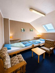 a room with four beds and a couch and a table at Hostel Suzzzy in Novska