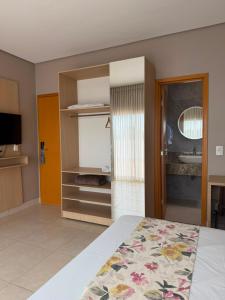ein Schlafzimmer mit Bett und ein Badezimmer mit Waschbecken in der Unterkunft Ventura Hotel in Barreiras