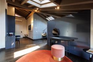 a room with a black table and a pink stool at Palazzo Utini in Noceto