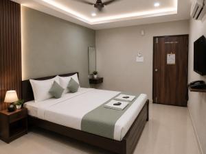 a bedroom with a large bed and a television at Hotel Rise Grand Kukatpally Near Hitex Exhibition Center & Nexus Mall, Yashoda Hospital in Hyderabad