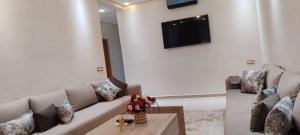 a living room with a couch and a tv on a wall at تاركة مراكش in Marrakesh