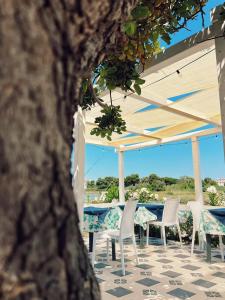 a table and chairs under an umbrella on a patio at B&B Torre del Lago 1 in Foce Varano