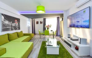 a living room with a green couch and a tv at Harmony Suites in Bucharest