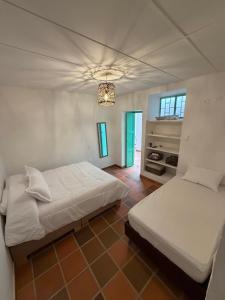 a bedroom with two beds and a chandelier at Casa Natus Hostal in Zapatoca