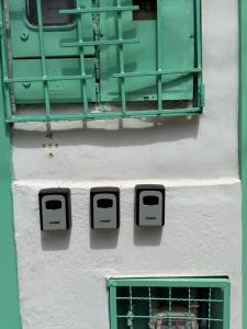 a building with two windows and a green at Casa Natus Hostal in Zapatoca