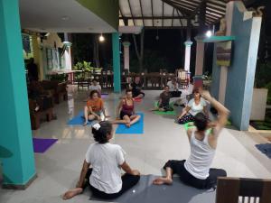 a group of people sitting on the floor doing yoga at Rimaka Village - Tourist Board Approved Hotel in Habarana