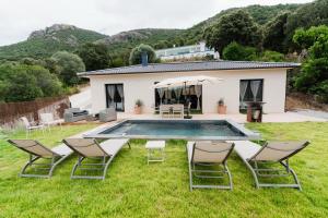 a backyard with a pool and chairs and a house at Villa Ezilia in Alata