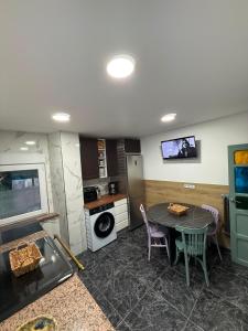 a kitchen with a table and a stove and a microwave at La casa de Ángel in Llombera