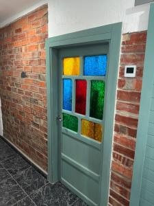 a door with colorful glass windows in a brick wall at La casa de Ángel in Llombera