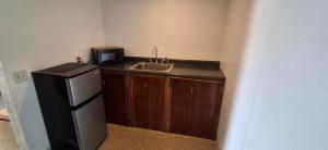 a small kitchen with a sink and a refrigerator at M Star Hotel Mansfield in Mansfield