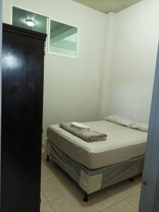 a bed in a room with a black cabinet at EdificioSsur 0601 in Choluteca