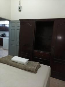 a bedroom with a bed and a dresser with two towels at EdificioSsur 0601 in Choluteca
