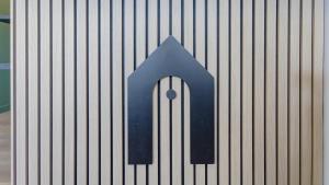 a blue arrow sign on the side of a building at Campanile Epernay - Dizy 51530 in Épernay
