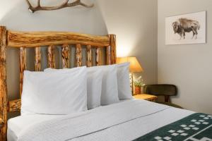 a bedroom with a bed with a wooden headboard at The Evergreen in West Yellowstone
