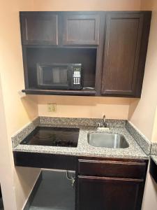 a kitchen with a sink and a microwave at Paradise Inn & Suites in Baton Rouge +27 photos