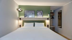 a bedroom with a white bed and a green wall at Campanile Epernay - Dizy 51530 in Épernay