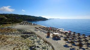 a beach with chairs and umbrellas and the water at Villa Florineth in Simius