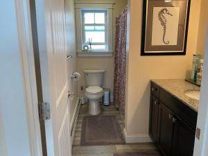 a bathroom with a toilet and a window at Roberts Lake House Room #3 in Colchester +8 photos