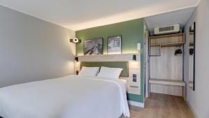 a bedroom with a large white bed and green walls at Campanile Epernay - Dizy 51530 in Épernay +16 photos