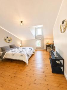 a bedroom with a bed and a desk and a television at chambres d'hotes des capellas in Bessens