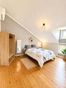 a large bedroom with a bed and a wooden floor at chambres d'hotes des capellas in Bessens +14 photos