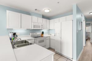 a kitchen with white appliances and blue walls at Atlantic Sunrise in Tybee Island
