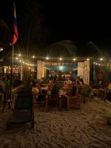 a group of people sitting on a beach at night at Hostal Nomadax Tayrona in El Zaino +20 photos