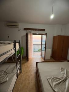 a bedroom with two bunk beds and a balcony at Villa Denis Gjeta in Borsh
