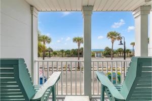 two chairs on a porch with a view of the beach at Atlantic Sunrise in Tybee Island