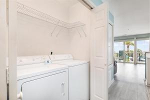 a white laundry room with a washer and dryer at Atlantic Sunrise in Tybee Island