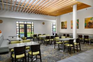 a dining room with tables and chairs and windows at Residence Inn by Marriott Palo Alto Menlo Park in Menlo Park