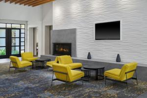 a waiting room with yellow chairs and a fireplace at Residence Inn by Marriott Palo Alto Menlo Park in Menlo Park