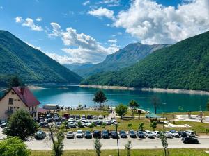 a parking lot next to a lake with mountains at Apartment LAKEVIEW in Plužine