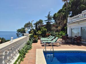 a house with a swimming pool next to the ocean at La Marina in Lloret de Mar