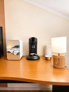 a coffee maker and a lamp on a desk at chambres d'hotes des capellas in Bessens