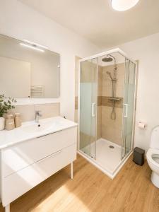 a white bathroom with a shower and a sink at chambres d'hotes des capellas in Bessens