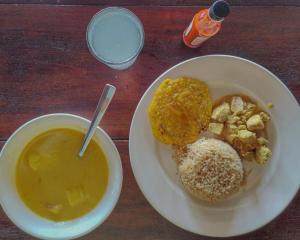 a plate of food with a bowl of soup and bread at Posada Don Aí in El Valle