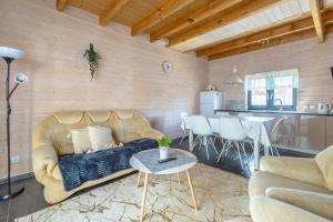 a living room with a couch and a table at Domki Kalipso in Sarbinowo