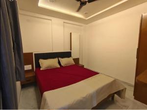a bedroom with a bed with a red blanket at ishwari heights lodging in Pandharpur