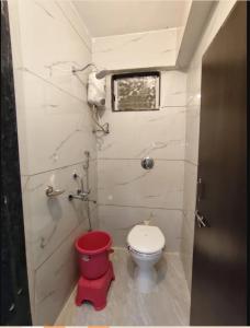 a small bathroom with a toilet and a window at ishwari heights lodging in Pandharpur